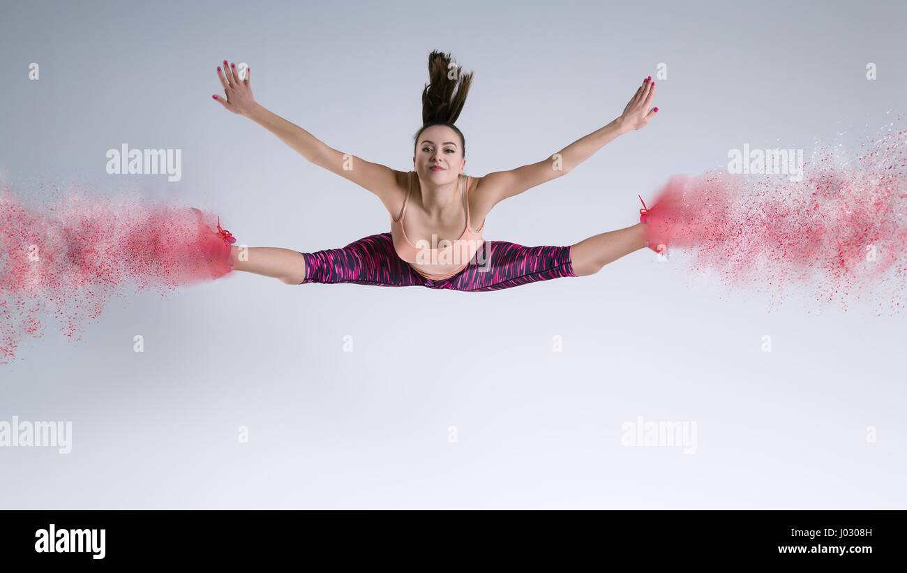 La donna nel salto in studio e effetto di disintegrazione Foto Stock