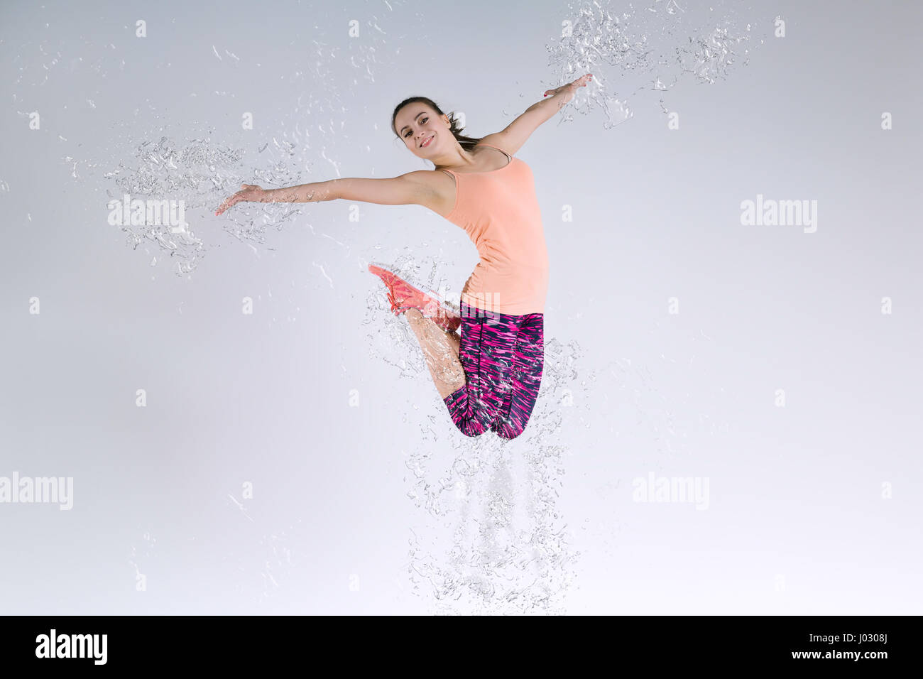 Donna che si tuffa in studio e spruzzi d'acqua Foto Stock