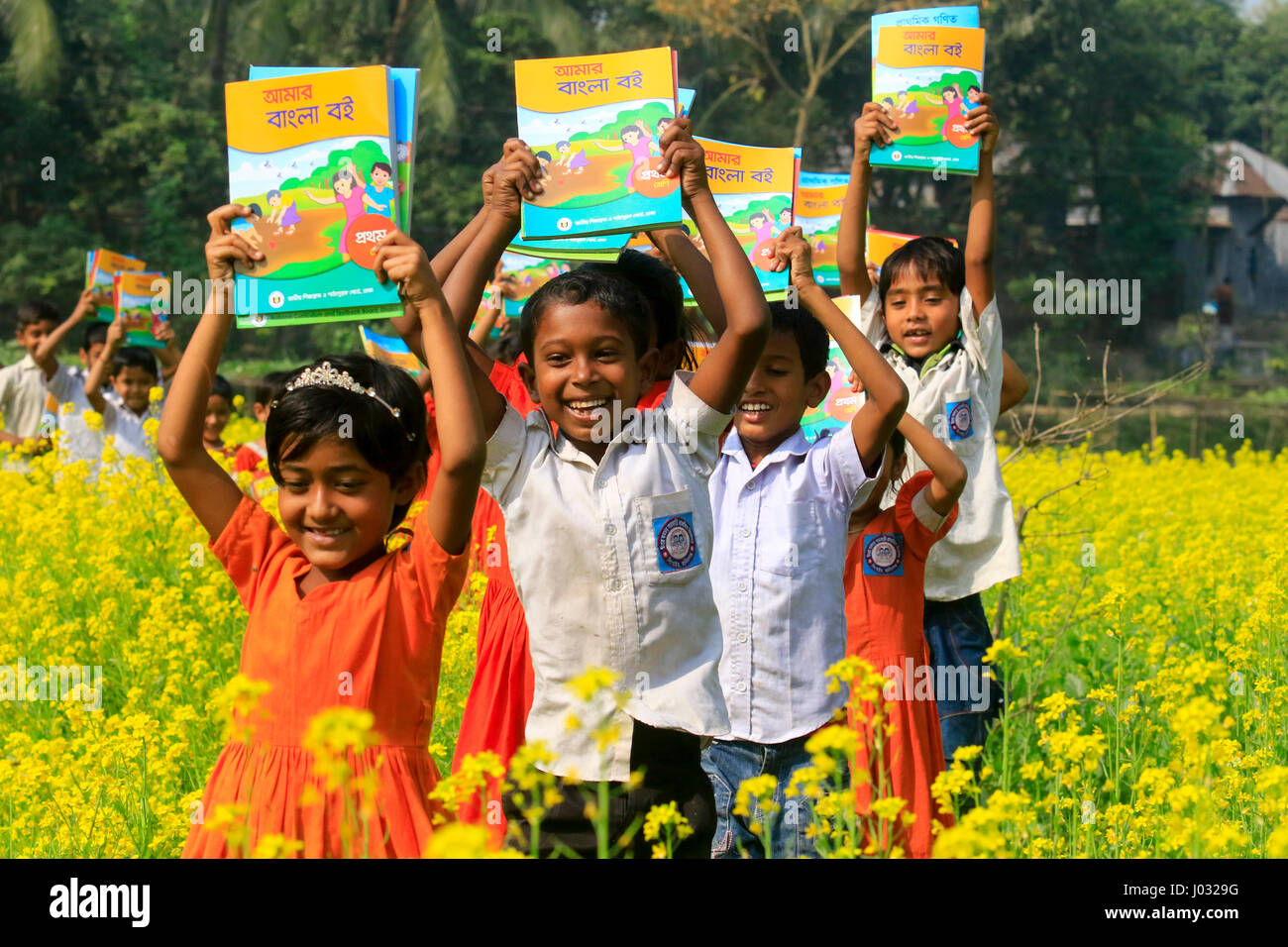 Gli studenti celebrare come si ricevono i nuovi libri di testo per le nuove classi a Singair in Manikganj, Bangladesh. Foto Stock