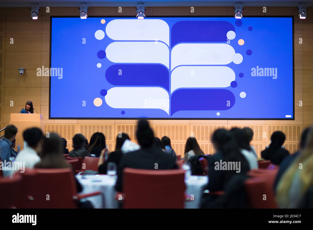 Un grande schermo di presentazione di fronte ad un uditorio durante un evento Foto Stock