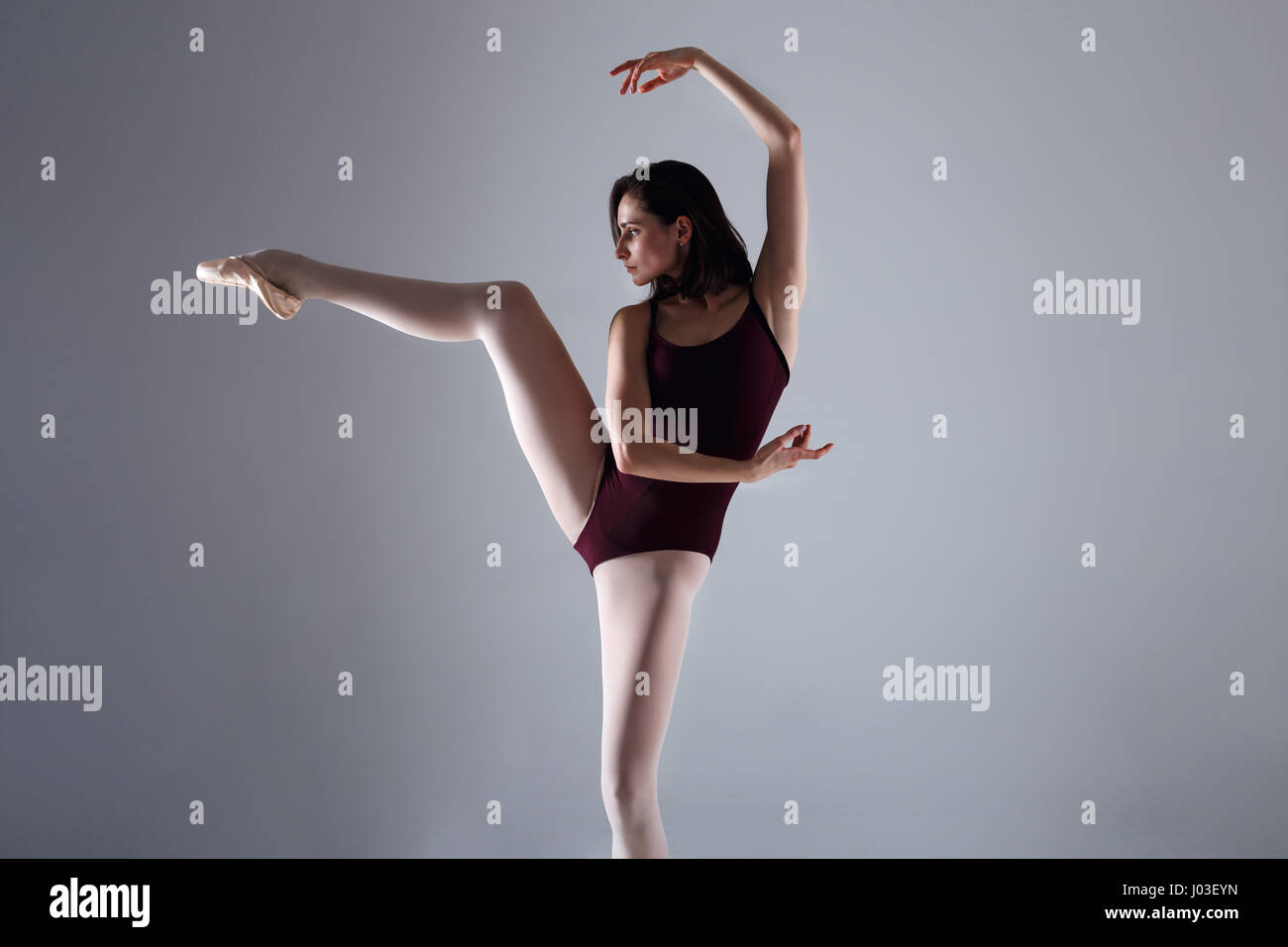 Slim ballerina è Dancing in the white studio nella luce di contrasto Foto Stock