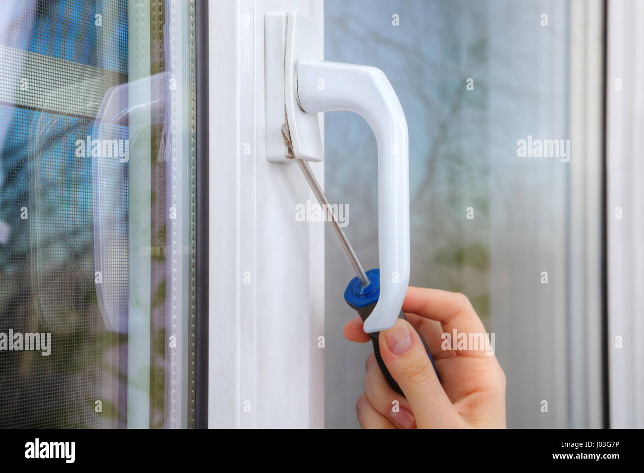 Smontare la maniglia in una finestra in pvc con un cacciavite, close-up di  una mano con un attrezzo Foto stock - Alamy