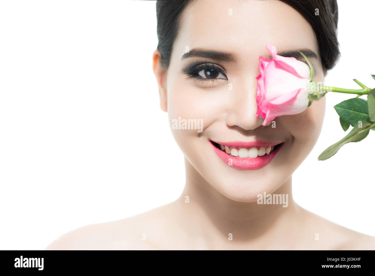 Copia del ritratto distanziate di una bella signora con un fiore rosa su sfondo bianco. Donna giorno concetto. Primo piano volto nuovo ragazza. Foto Stock