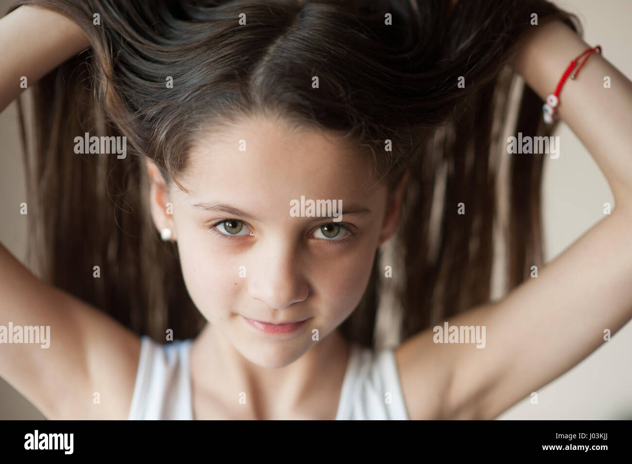 Bellissima fanciulla si raddrizza i suoi capelli Foto Stock