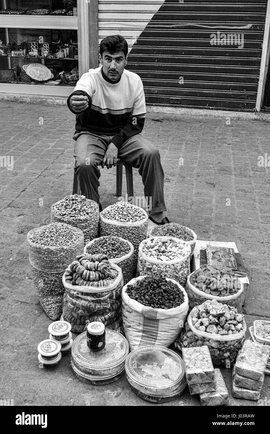 Venditore a vendere la frutta secca e i dadi sulla strada di Damasco, Siria. Foto Stock