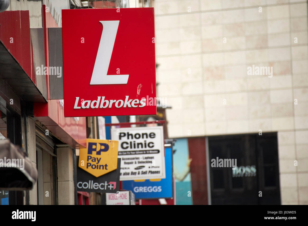 Ladbrokes e vari piccoli segni aziendali sulle vetrine del centro città di Liverpool Regno Unito Foto Stock