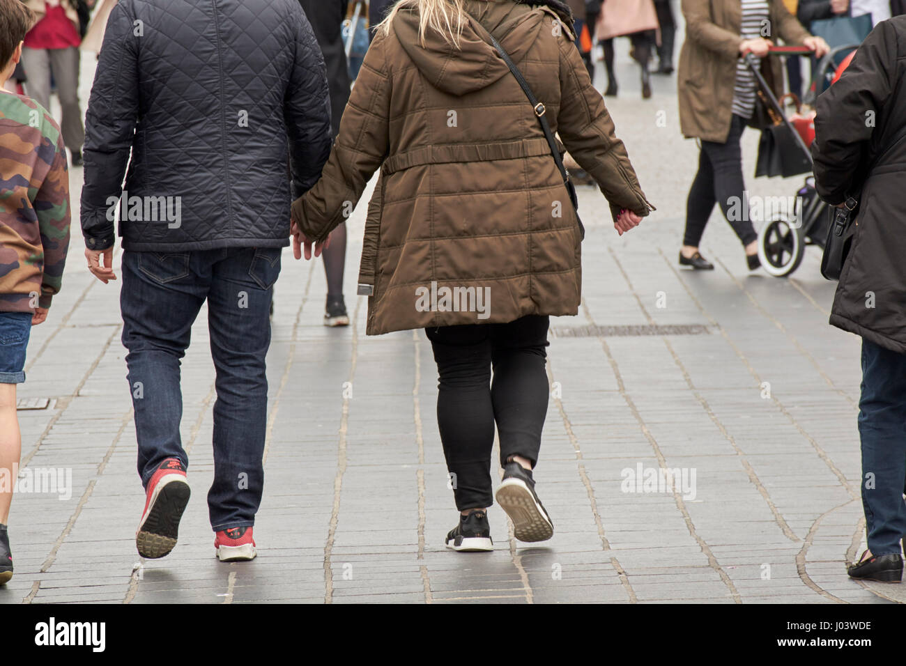 Giovane camminando lungo tenendo le mani sul giorno di primavera nel centro città di Liverpool Regno Unito Foto Stock