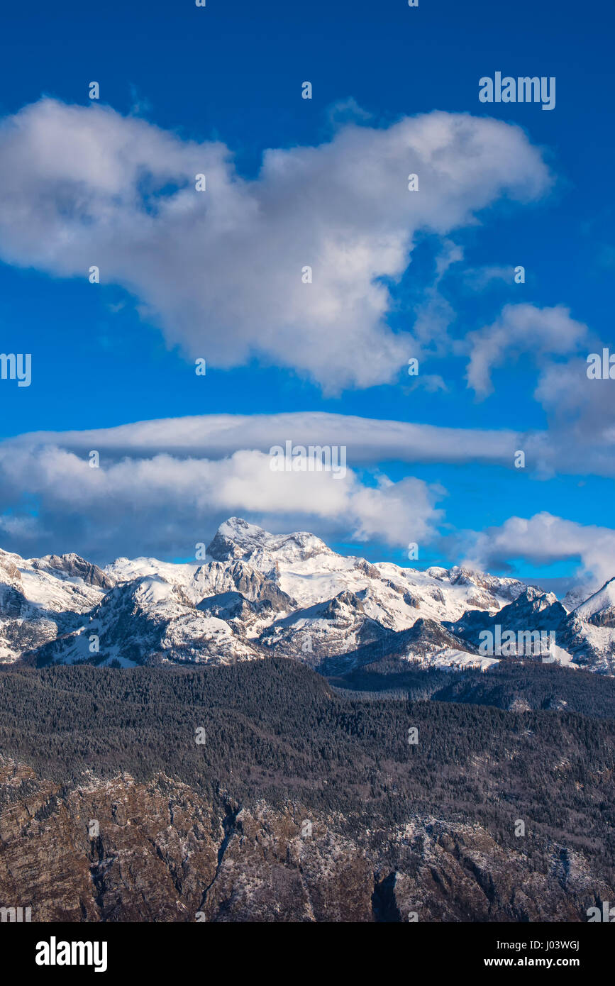 Triglav bellissimo paesaggio di montagna sulla soleggiata giornata invernale con le nuvole. Foto Stock