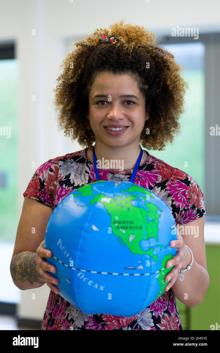 Insegnante in una classe tenendo un Blow up globo per la fotocamera. Foto Stock