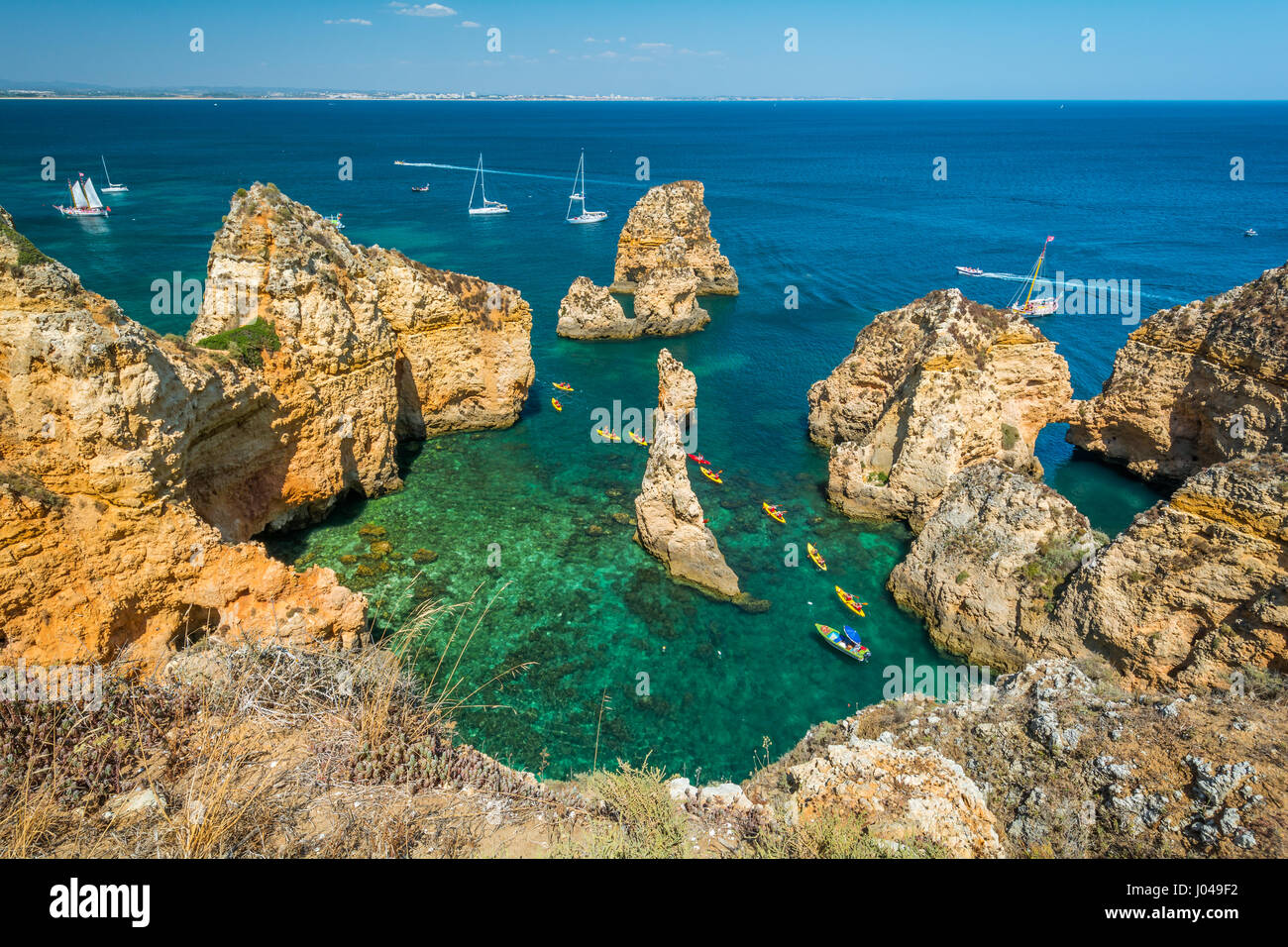 Scenic scogliere dorate e acque color smeraldo di Ponta da Piedade, Lagos, Algarve, PORTOGALLO Foto Stock