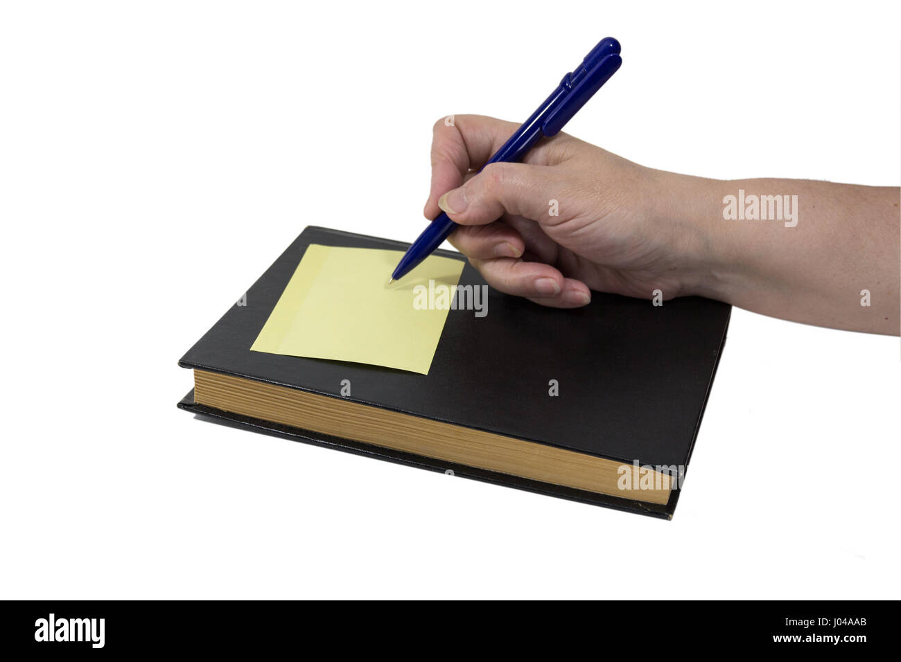 Adesivo giallo è incollato al libro scuro Foto Stock