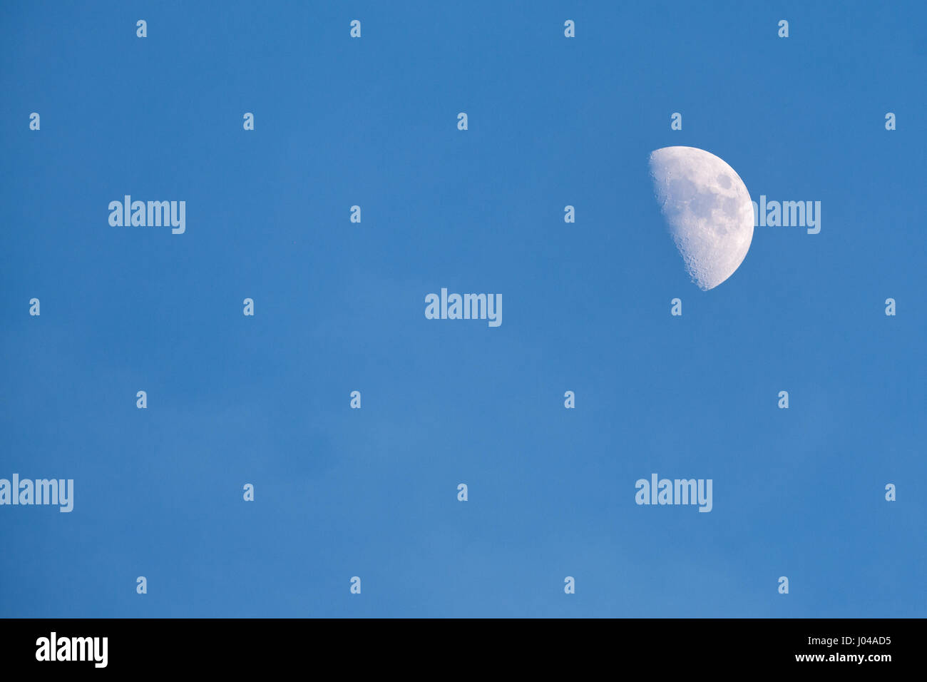 Mezza luna nel cielo blu Foto Stock