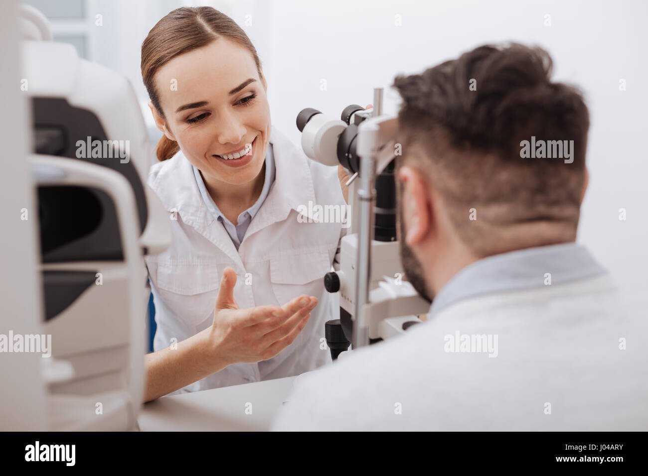 Felice gentile all'ottico optometrista interagenti con il suo paziente Foto Stock