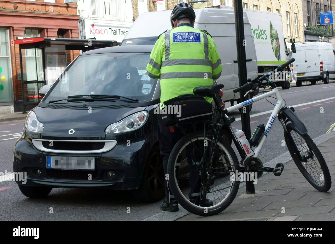 La polizia di sostegno comunitario questioni Officer i biglietti per il parcheggio, Islington, Londra Foto Stock