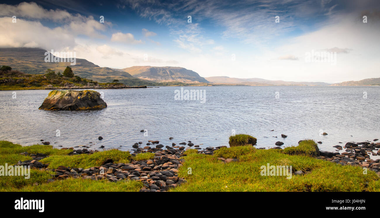 Montagne luogo dalle sponde rocciose di Loch Torridon, un mare loch nel nord ovest Highlands della Scozia. Foto Stock