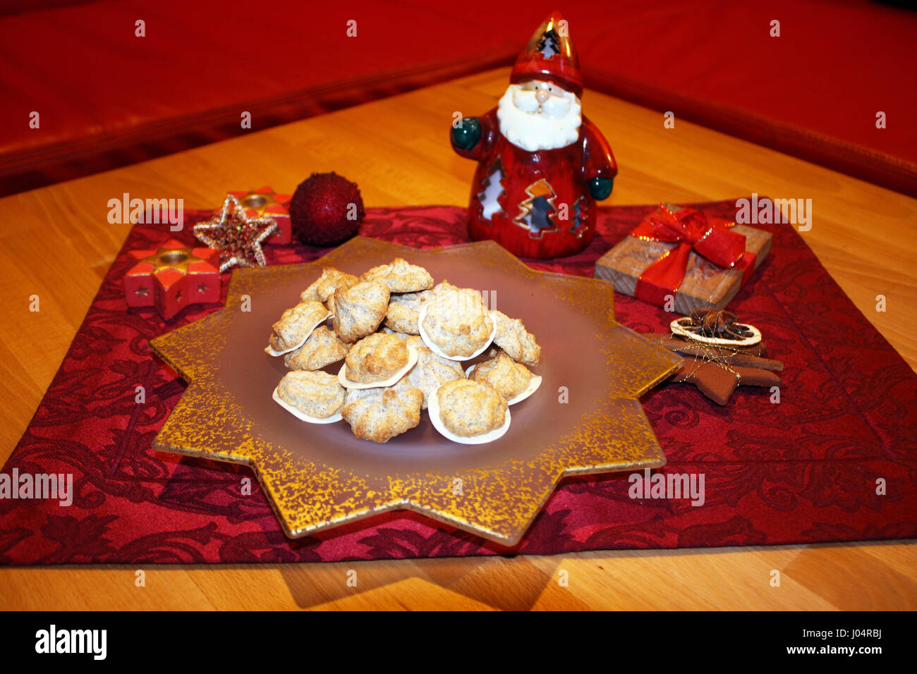 Gebackene Walnuss Makronen auf einem Stern Teller mit kleiner Tischdecke einem Windlicht in forma Nikolaus, einem modello, Einem Zimtstern und Schleife Foto Stock