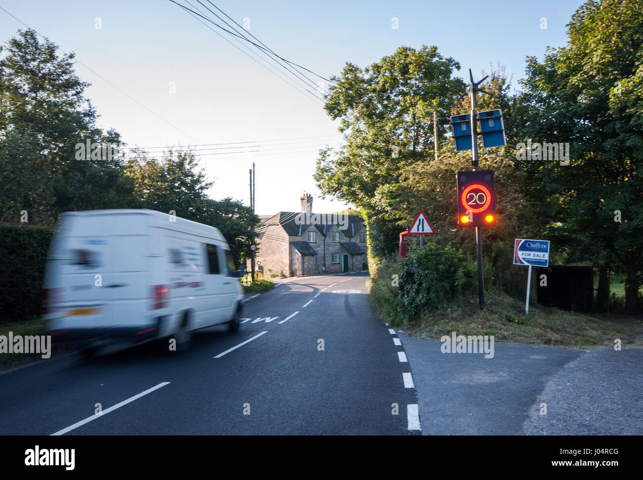 Shaftesbury, England, Regno Unito - 28 Luglio 2012: il traffico precipita attraverso Melbury Abbas villaggio nelle zone rurali del nord del Dorset, attivazione di un regolatore elettronico di velocità limite sig Foto Stock