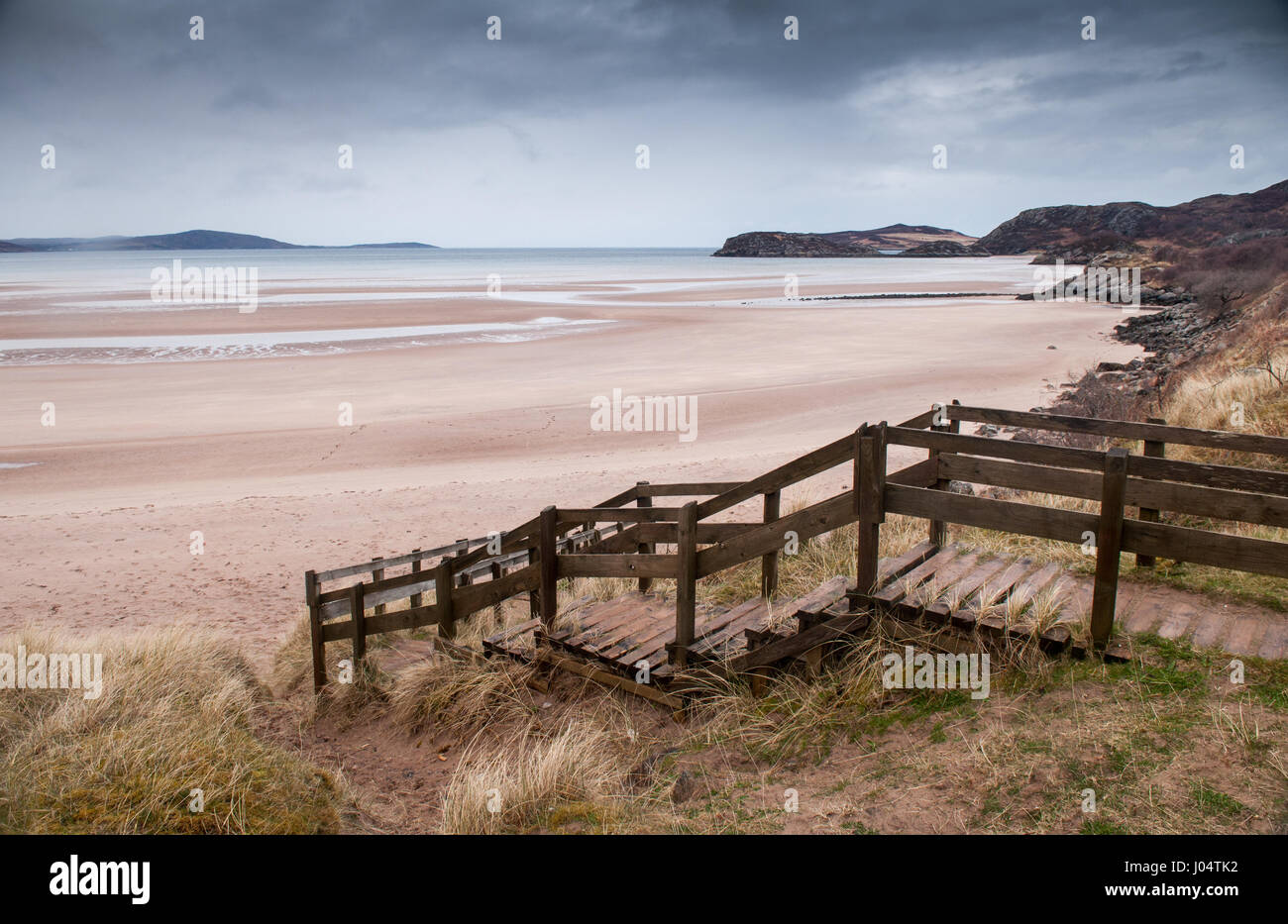 Passerella in legno passi attraversare le dune di sabbia e conducono giù alla spiaggia di Gruinard Bay nel remoto nord ovest Highlands della Scozia. Foto Stock