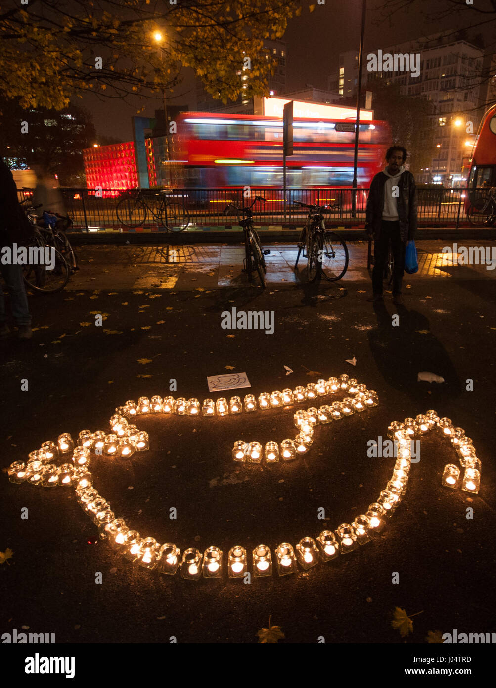 London, England, Regno Unito - 16 Novembre 2012: Candele sono disposti nella colomba logo della campagna Roadpeace gruppo in corrispondenza di un bordo strada veglia e la protesta. Foto Stock