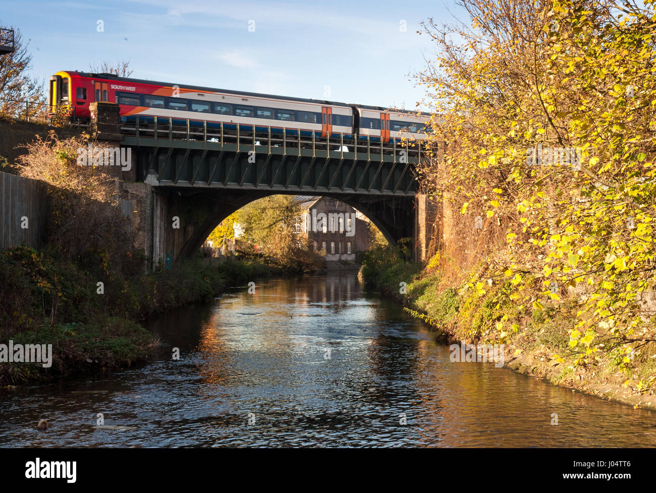 London, England, Regno Unito - 18 Novembre 2012: a sud ovest di classe I treni diesel 159 treni passeggeri attraversare il fiume Wandle a Earlsfield a Wandsworth. Foto Stock