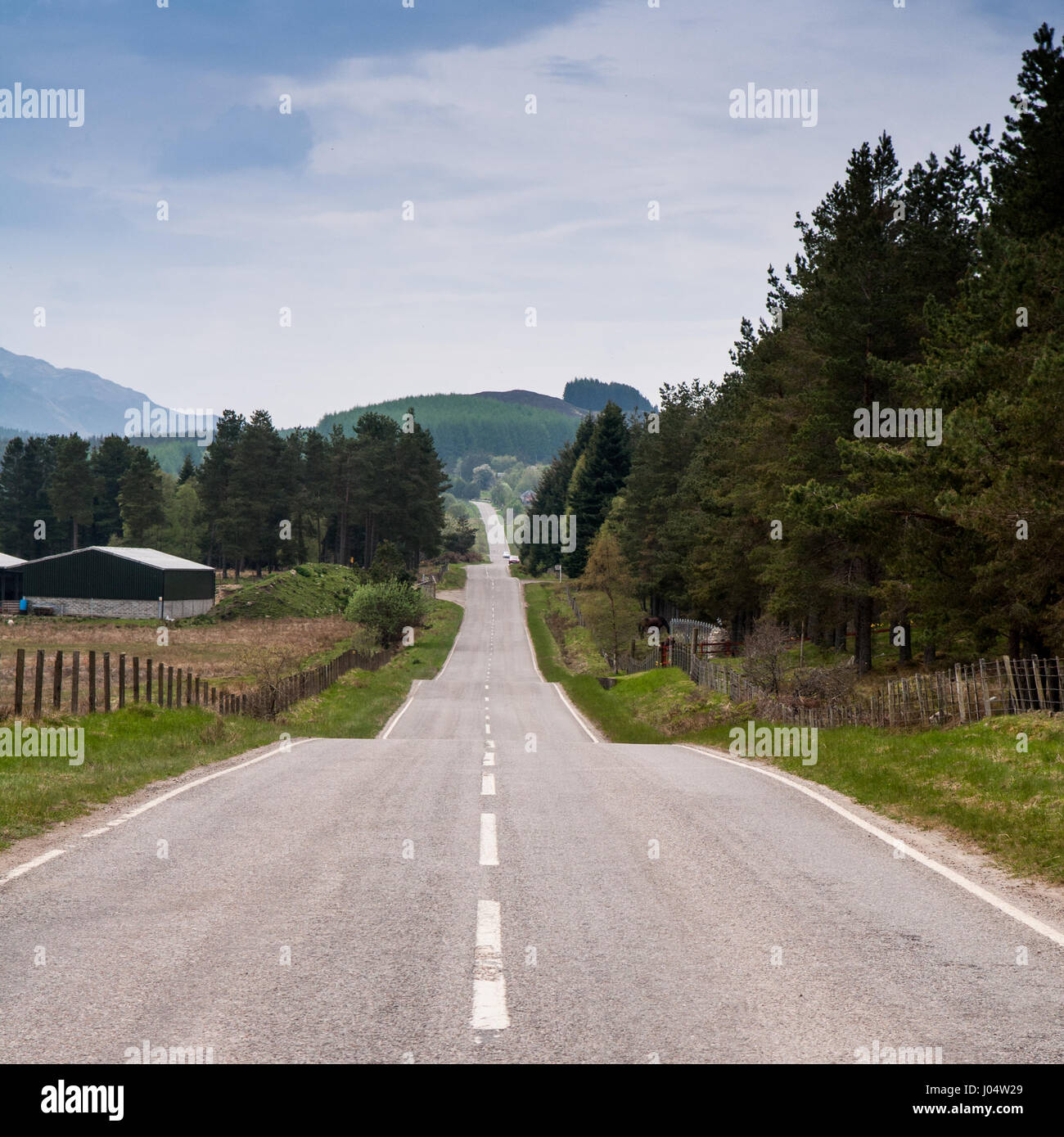 La lunga e dritta del xviii secolo strada militare del generale George Wade attraversa remote paesaggio ondulato di Stratherrick nelle Highlands della Scozia. Foto Stock