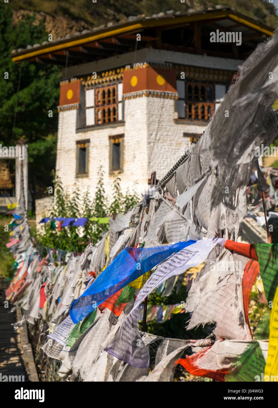 PARO, Bhutan - circa ottobre 2014: ferro Ponte Catena e bandiere di preghiera al Tachog Lhakhang Dzong Foto Stock