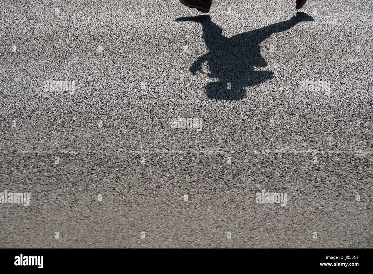 Ombra di un irriconoscibile runner su asfalto Foto Stock