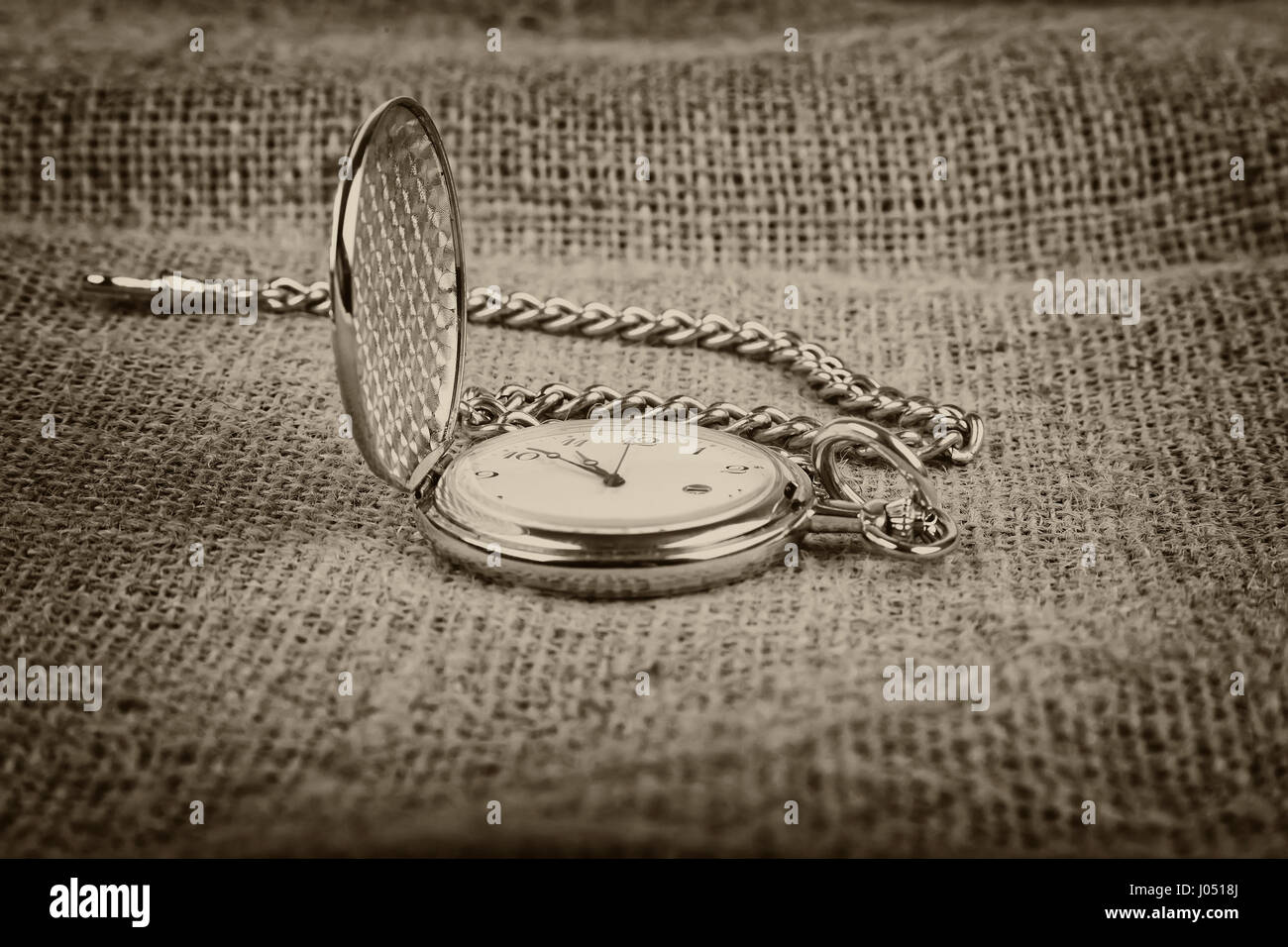 Oro antico orologio da tasca su tela sfondo, tonalità seppia Foto Stock