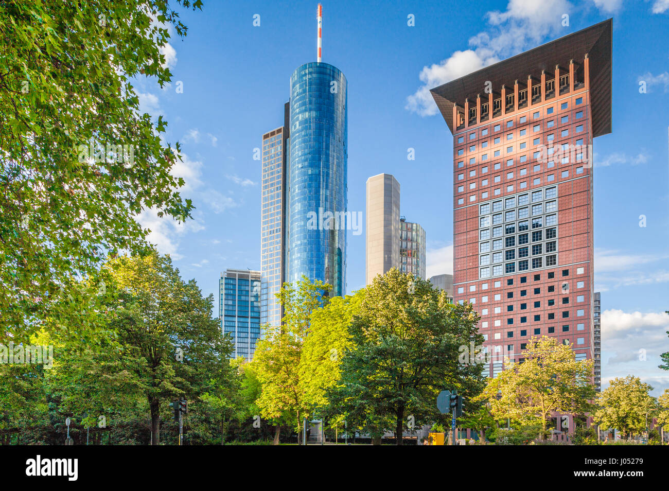 Vista panoramica di moderni grattacieli del quartiere finanziario di Francoforte sul Meno con verdi alberi nel parco pubblico in una bella giornata di sole in primavera Foto Stock