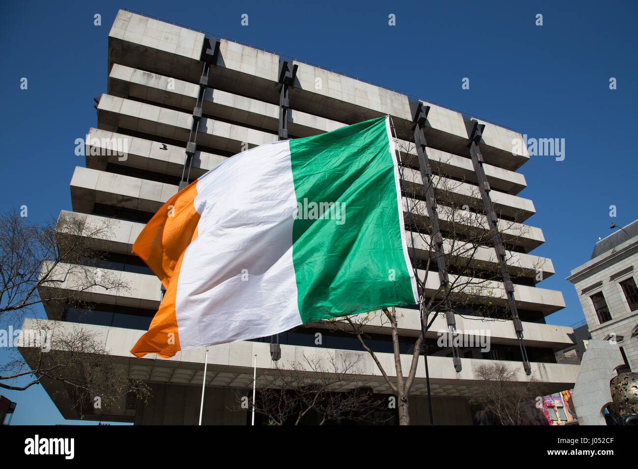 La bandiera irlandese di fronte la banca centrale nella città di Dublino, Irlanda. Foto Stock