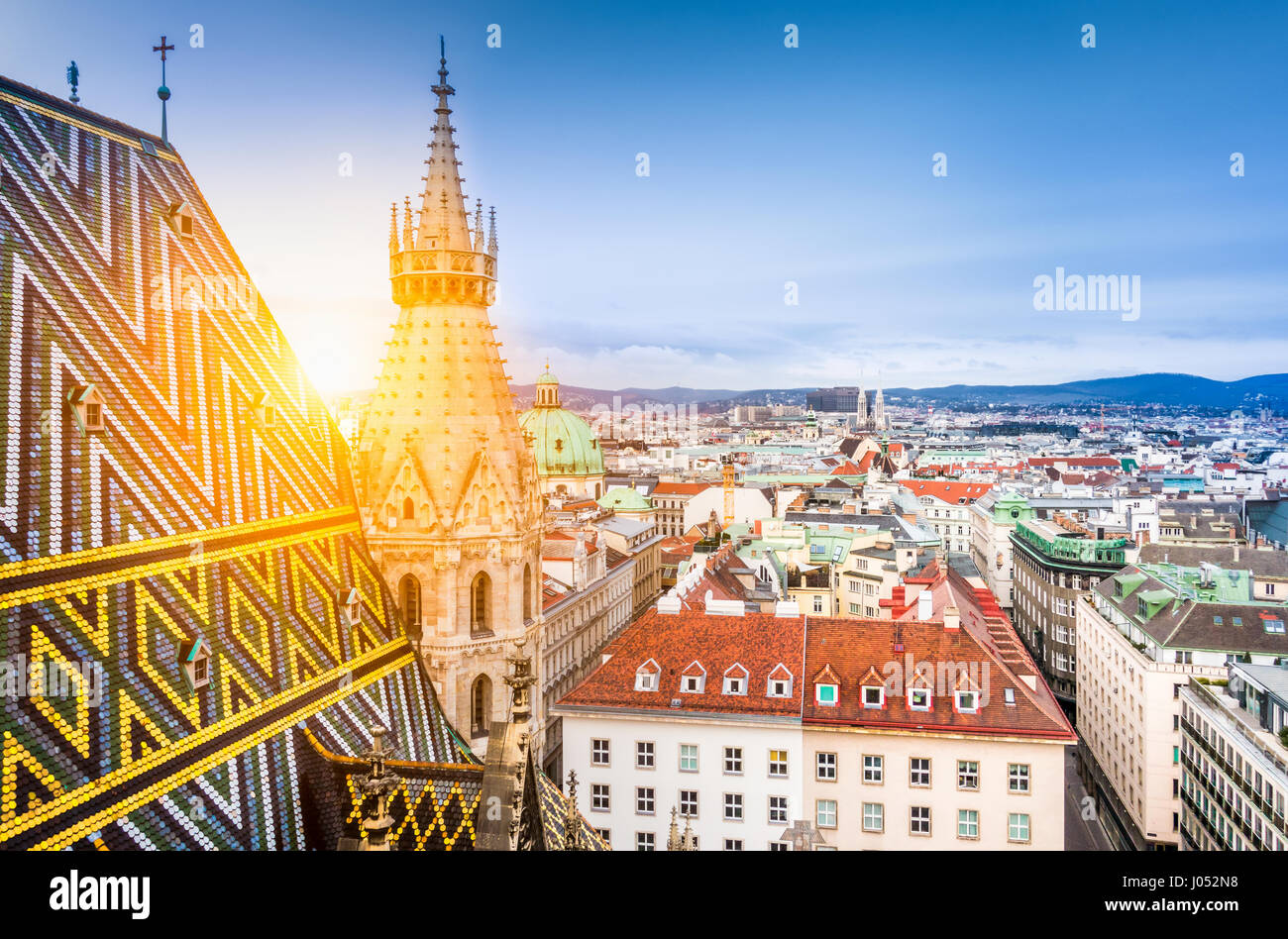 Vista aerea sopra i tetti storici di Vienna dalla torre nord della famosa cattedrale di Santo Stefano in beautiful Golden luce della sera al tramonto Foto Stock