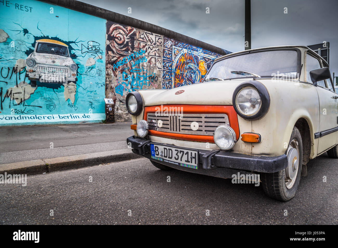 Famosa Berliner Mauer (Berlino) Parete a East Side Gallery con una vecchia Trabant, il più comune veicolo utilizzato nella Germania orientale del centro di Berlino, Germania Foto Stock