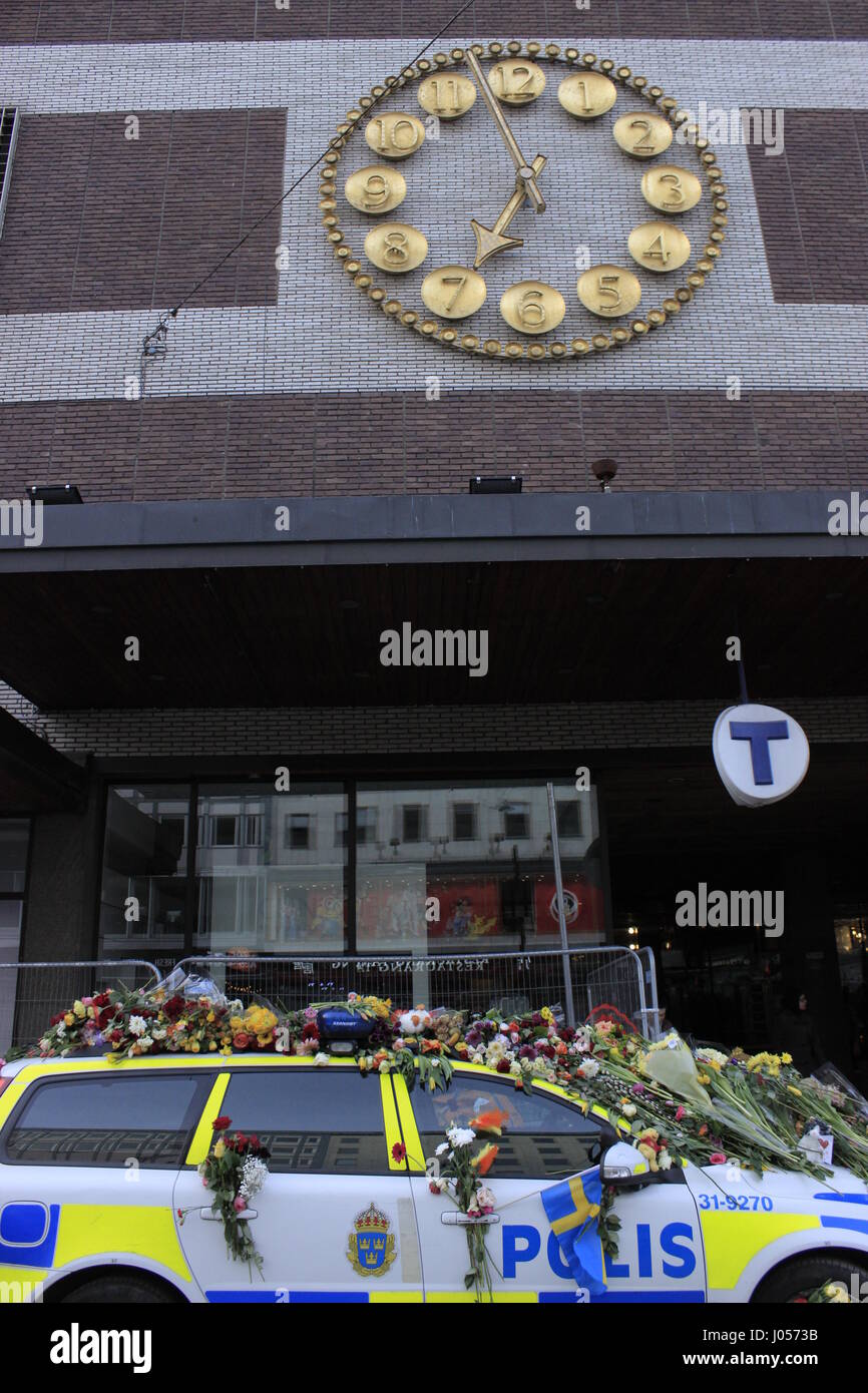 La polizia svedese (Polis) car completamente coperto di fiori e simpatia le frasi per le vittime del 7 aprile 2017 Stoccolma attacco terroristico, parcheggiate fuori Ahlens mall (Stockholm city stazione metro), con l'orologio mostra 18:57 circa. La città di Stoccolma, Svezia. 9 aprile 2017. Foto Stock