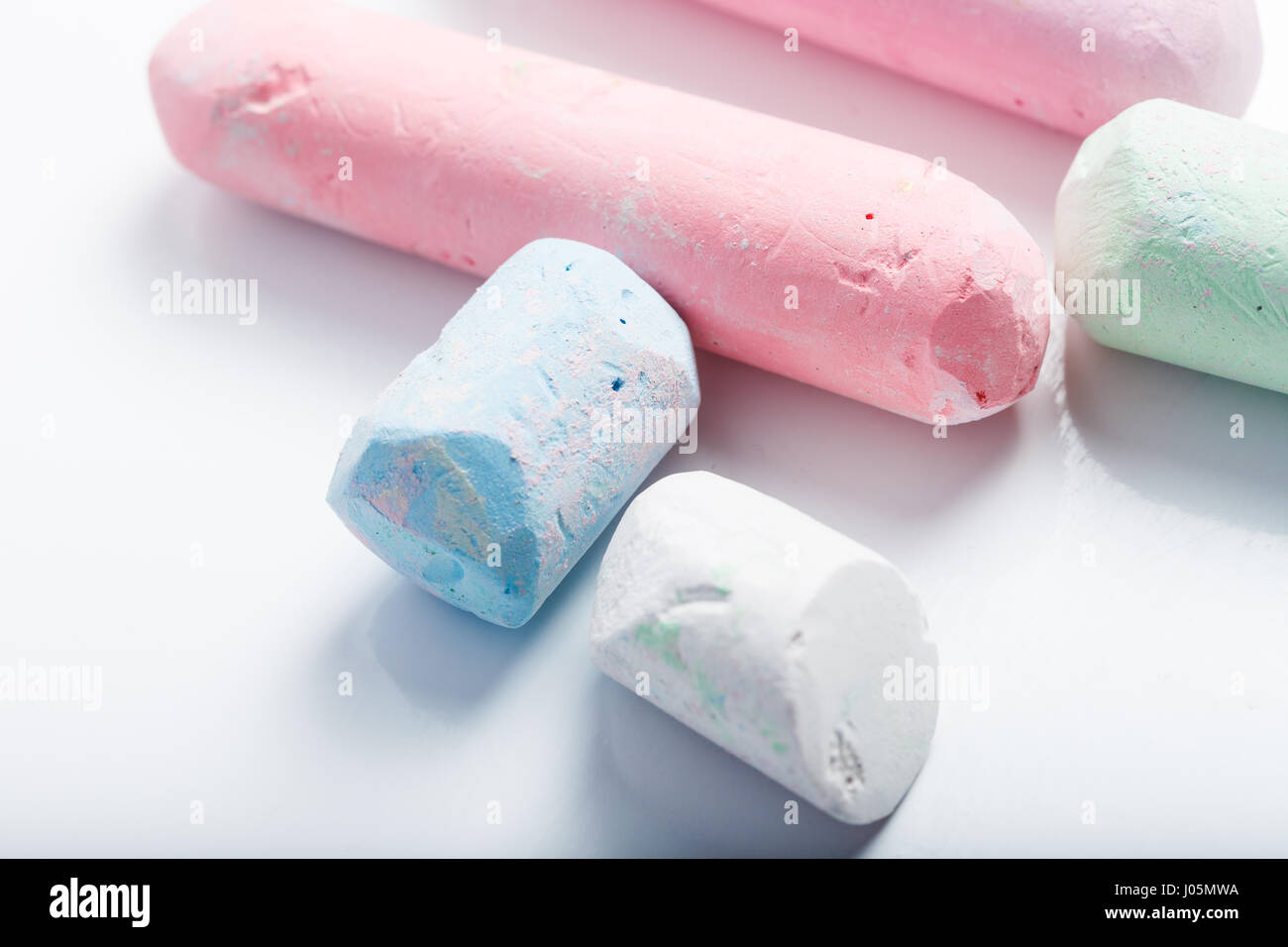 Chalk pezzi per scopo educativo, di differente colore e forma isolata su sfondo bianco Foto Stock