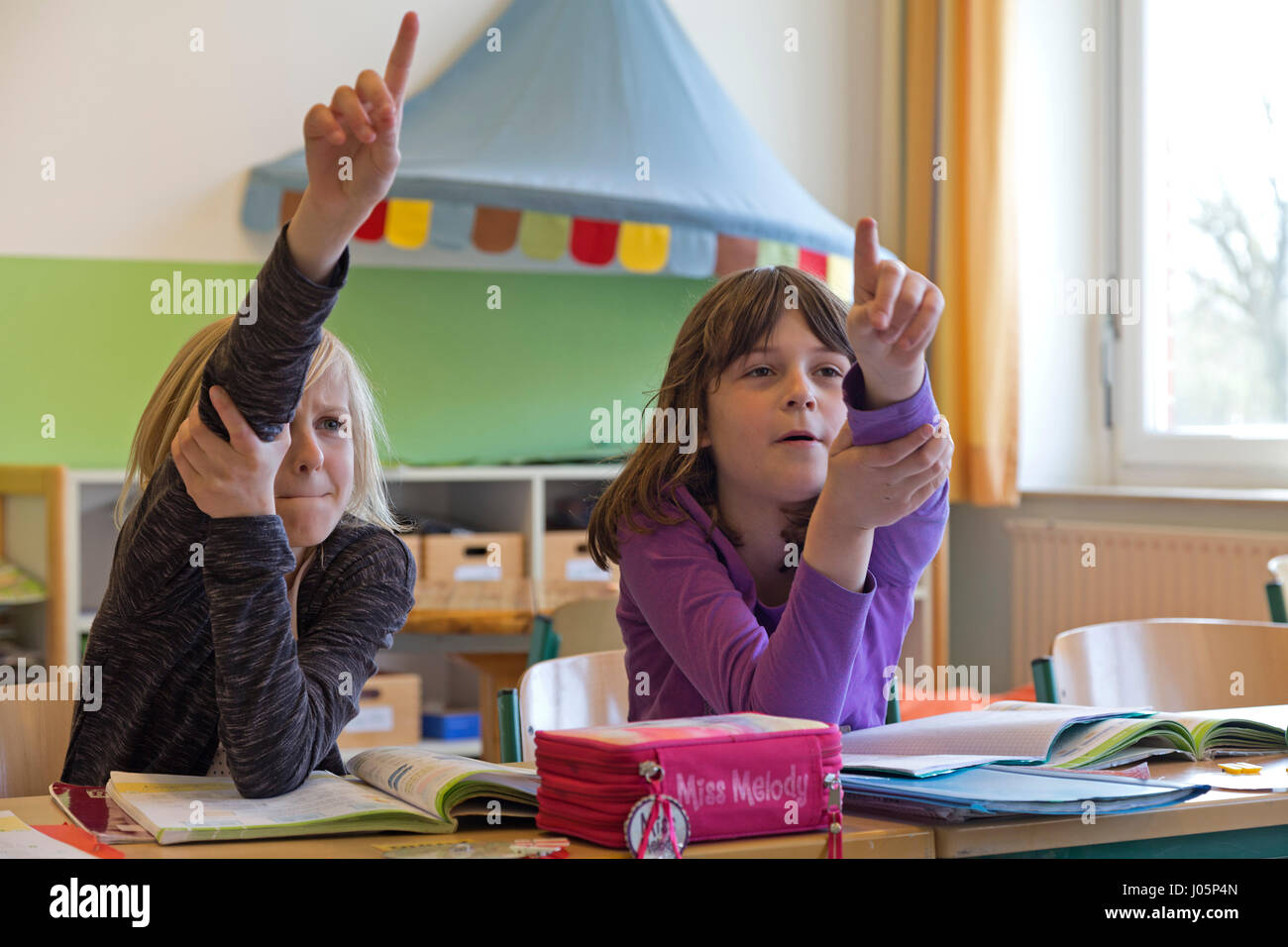 Alunni di scuola primaria alzando le mani, Bassa Sassonia, Germania Foto Stock