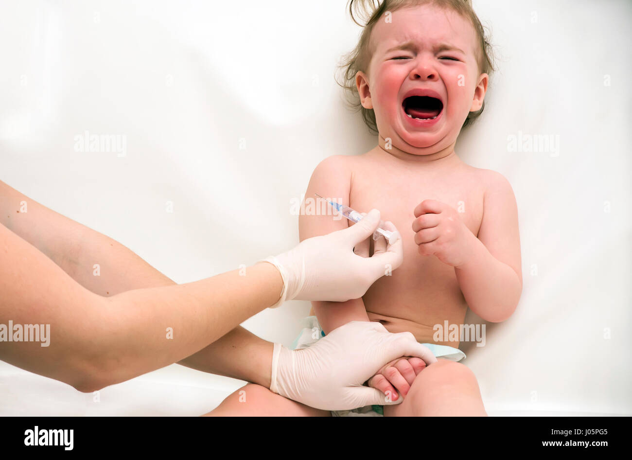 Siringa e Gridando bambino iniezione nel braccio Foto Stock