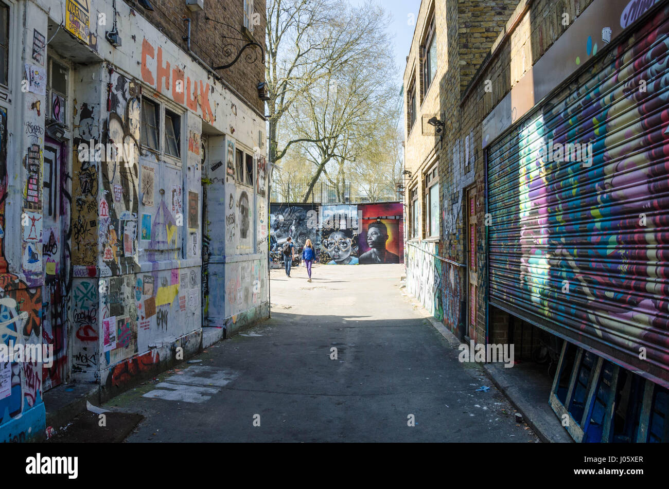 Un vicoletto principali off Brick Lane nella zona est di Londra è coperto con la street art e graffiti. Foto Stock