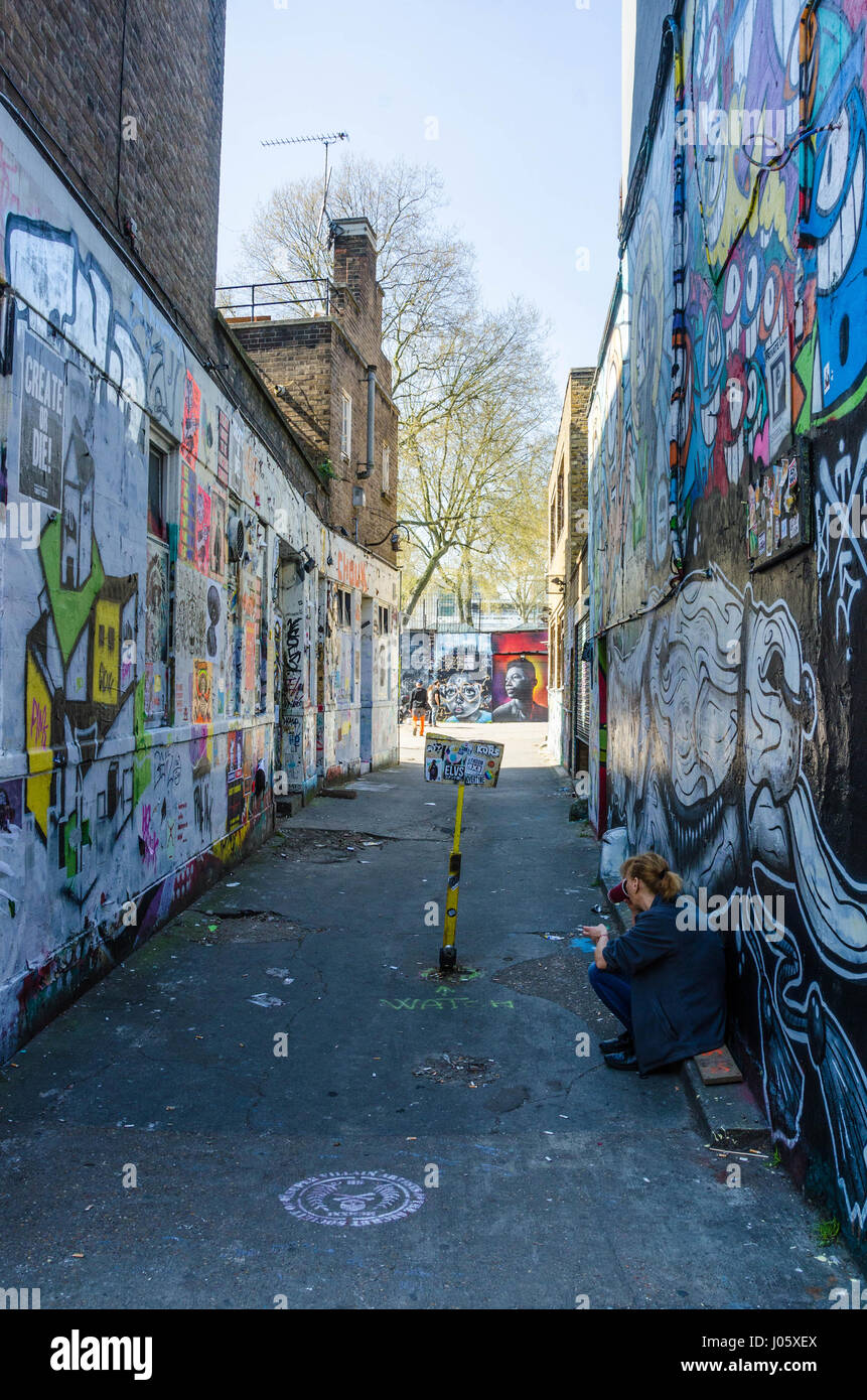 Un vicoletto principali off Brick Lane nella zona est di Londra è coperto con la street art e graffiti. Foto Stock