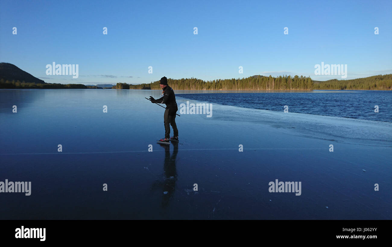 SPJUTMOSJON, Svezia: è questo il temerario brave o stupido dopo il pattinaggio su un lago ghiacciato dove il sottile strato di ghiaccio ha rotto fino a rivelare il congelamento sotto l'acqua? Riprese mozzafiato ha catturato un Adrenaline Junkie il pattinaggio sul ghiaccio e il salto tra i blocchi di ghiaccio senza una cura nel mondo. Il video mostra anche il brivido-cerca di skater di atterraggio su un glaçon come si comincia ad andare sotto e lui in maniera restrittiva evita di immergersi nel lago di peperoncino. Il clip è stato preso in Spjutmosjön, Svezia da ski shop lavoratore Johan Eriksson (26) da Hedemora. Esso mostra il suo amico Tobias Björklund diverte sul Foto Stock