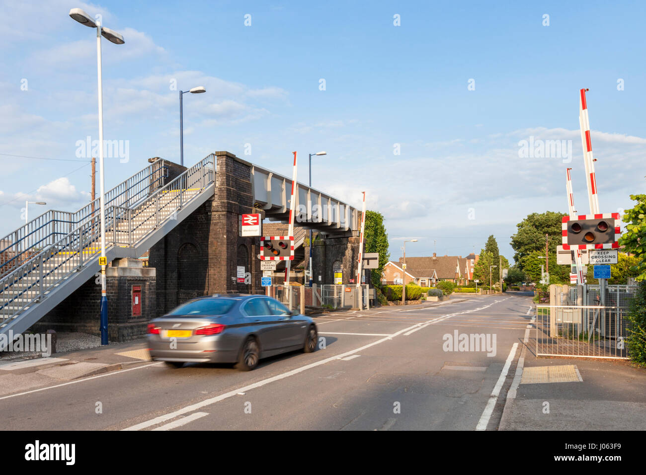 Passaggio a livello con barriere sollevato e car guida attraverso, Attenborough stazione ferroviaria, Nottinghamshire, England, Regno Unito Foto Stock