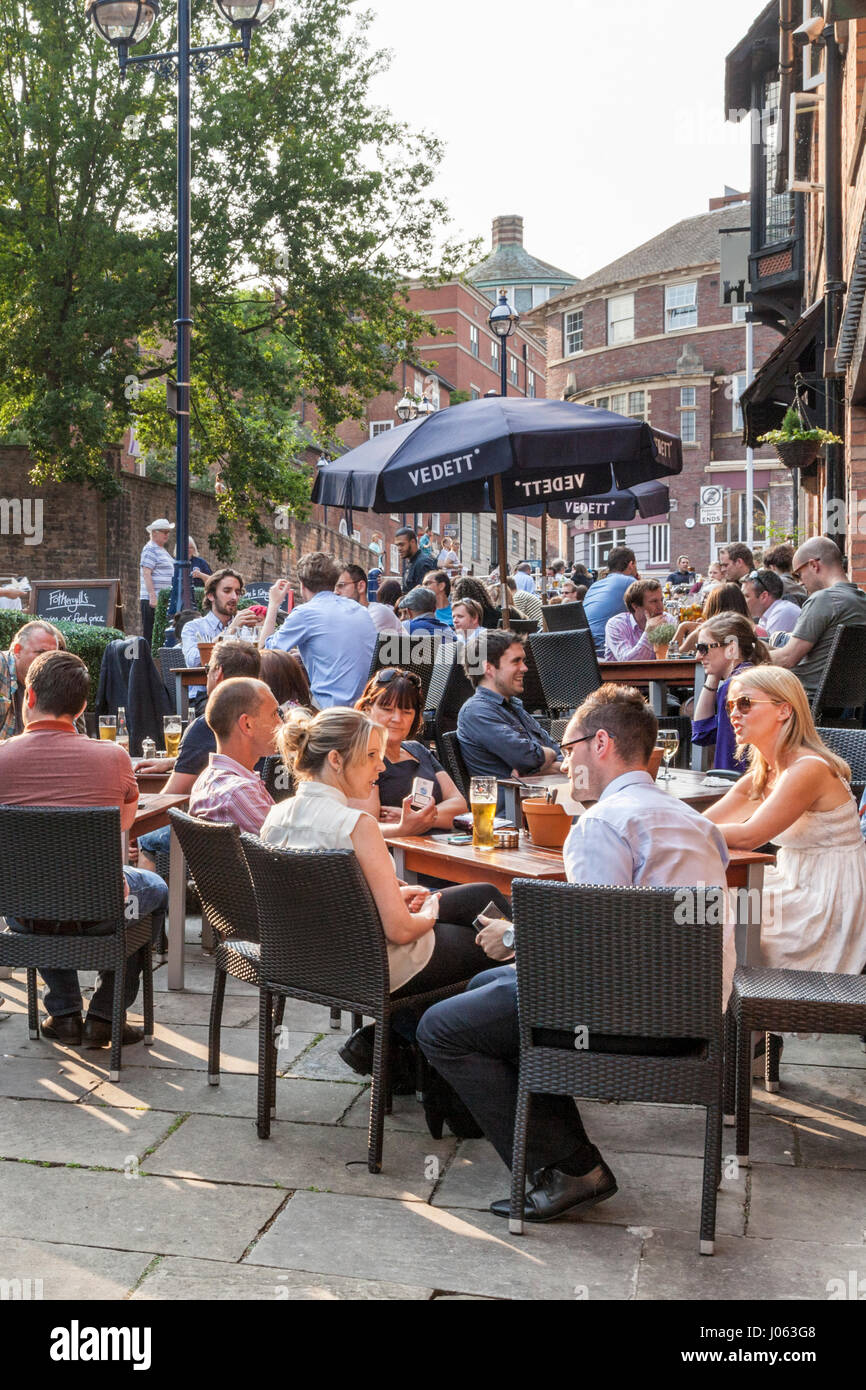 Persone seduti all'aperto in estate e di bere al di fuori della città di pub e bar, Nottingham, Inghilterra, Regno Unito Foto Stock