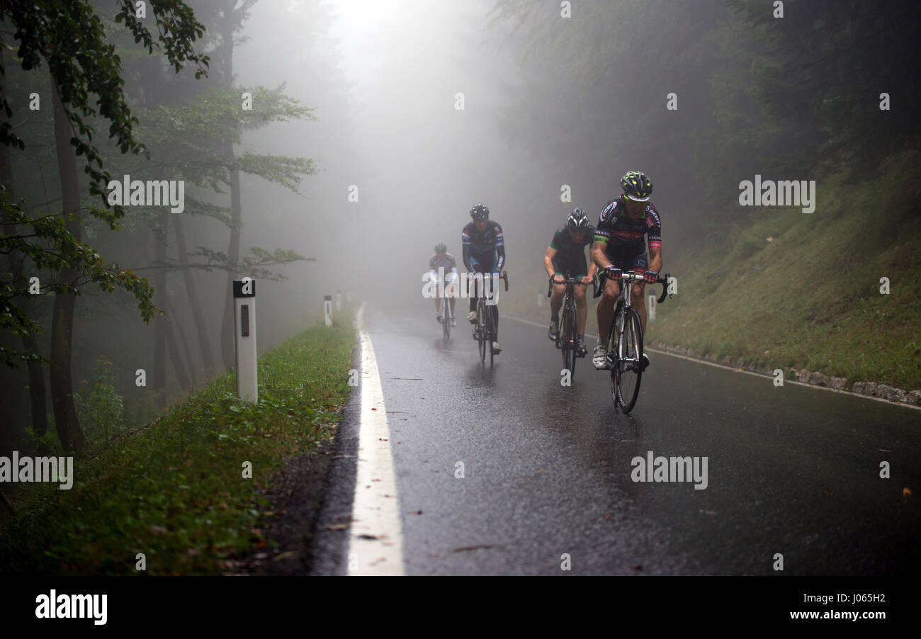 Un professional bike rider gare fino la montagna Geisberg nella nebbia e pioggia in bici da corsa gara Geisberg-Rennen 2015 vicino a Salisburgo Foto Stock