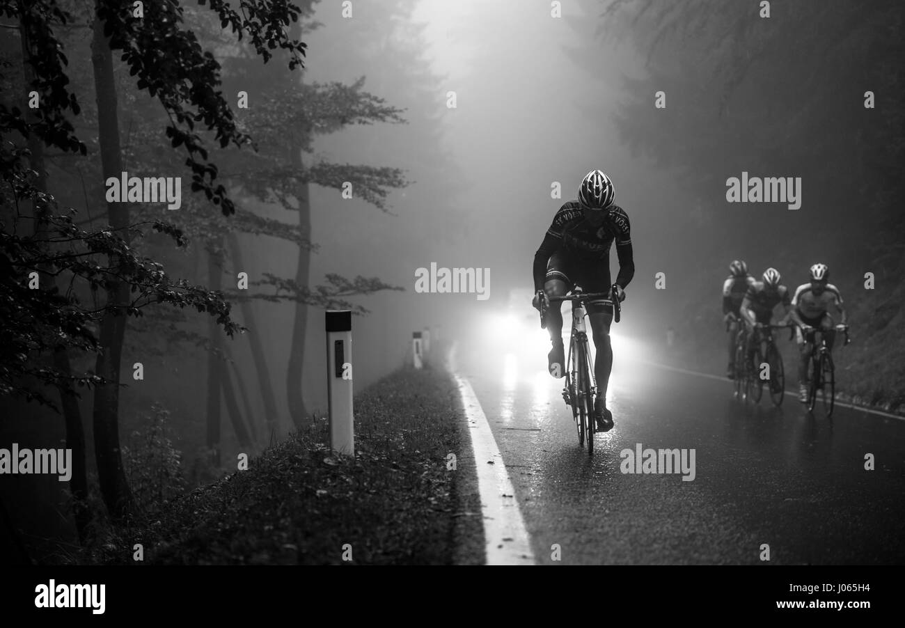 Un professional bike rider gare fino la montagna Geisberg nella nebbia e pioggia in bici da corsa gara Geisberg-Rennen 2015 vicino a Salisburgo Foto Stock