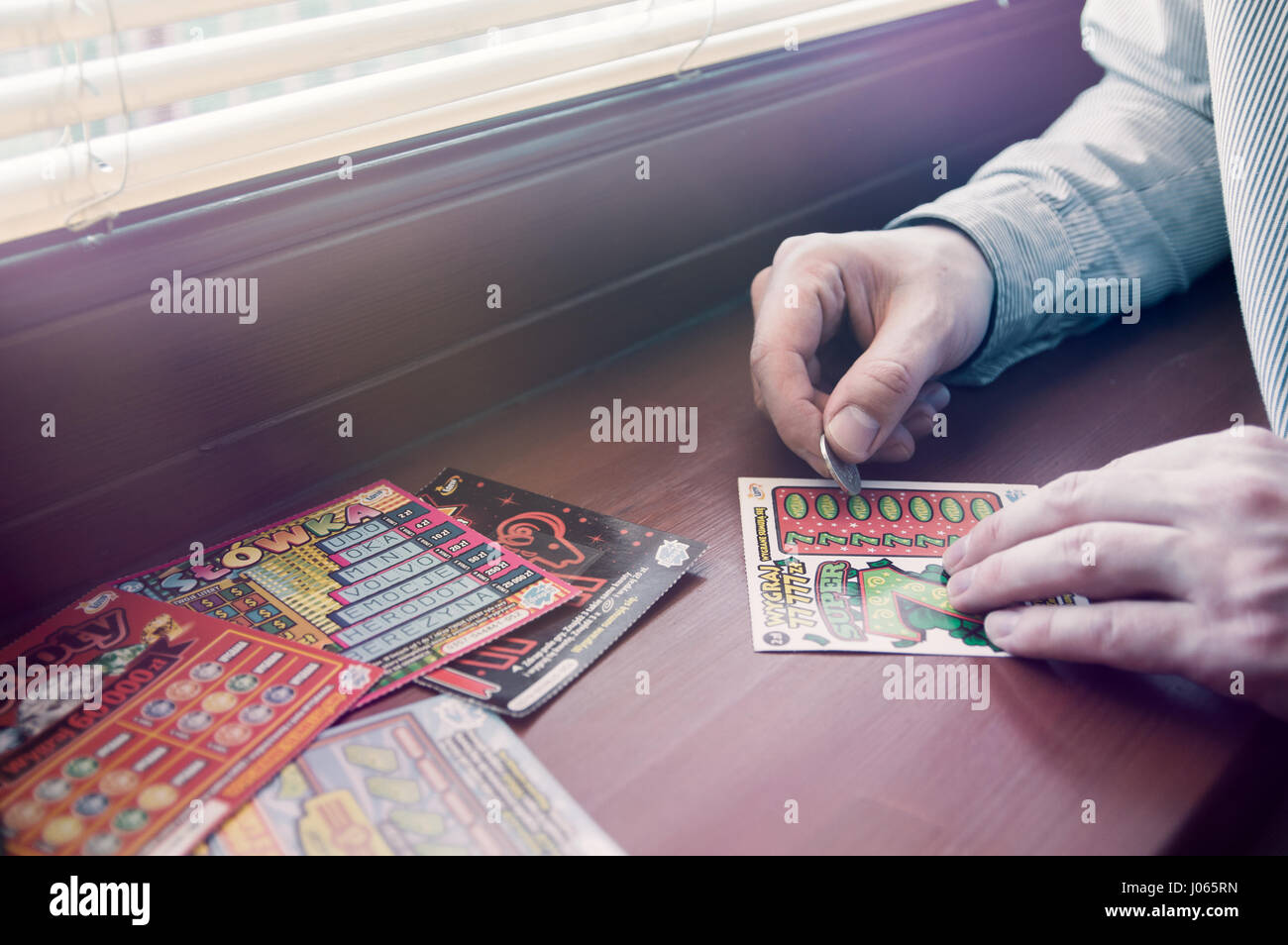 WROCLAW, Polonia - Marzo 28th, 2017: uomo polacco graffi lotteria gratta e vinci. Gratta e Vinci è una scheda piccola, dove le aree contengono informazioni nascoste Foto Stock