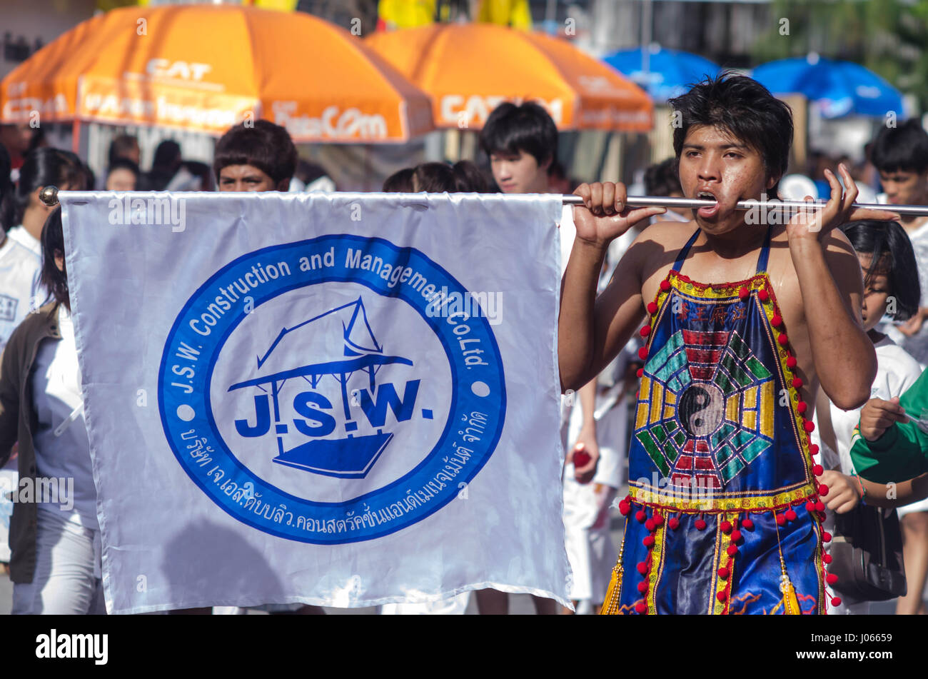 Un festival-goer con un flag pole attraverso le sue guance. Rifatti gli occhi con probabilmente il più hardcore gruppo di vegetariani si sono mai probabilità di vedere. Le spettacolari colpi di sangue tinto uomini mostrare loro perforazione coraggiosamente il loro guance con una varietà di oggetti appuntiti come ad esempio spiedini, grandi coltelli e aghi da maglia. Altre immagini mostrano gli uomini costringendo a più voci straordinarie attraverso la loro bocca compreso ombrelloni e un uomo anche la gestione per ottenere un intero pala attraverso le sue guance. L annuale Phuket Vegetarian Festival si svolge nel mese di ottobre. Foto Stock