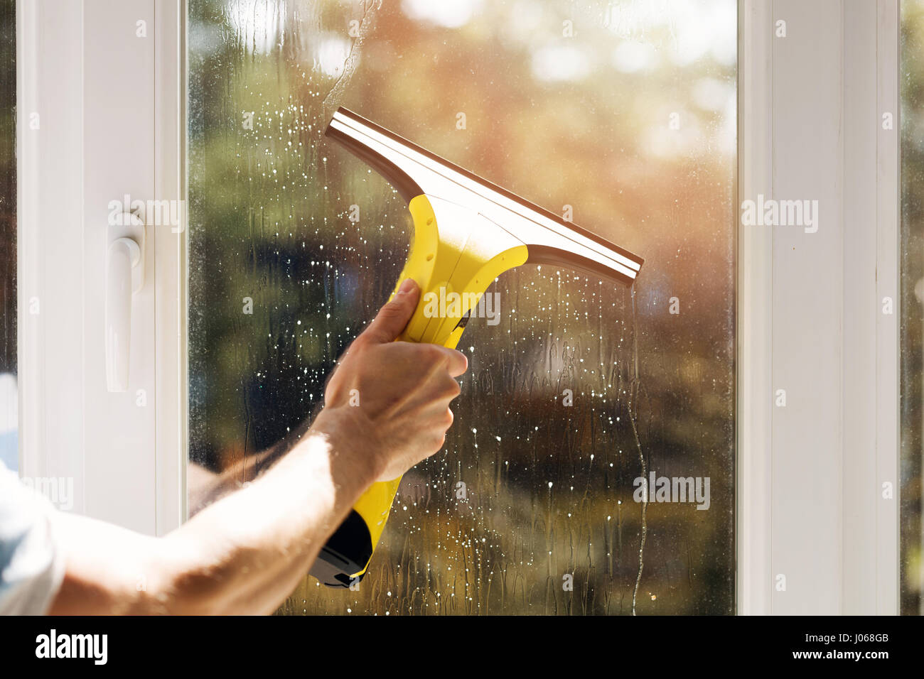 A mano nella finestra di pulizia con aspirapolvere Foto Stock