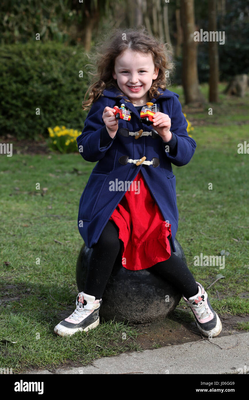 Una giovane ragazza nella foto al di fuori a giocare con lego in un parco a bognor regis, west sussex, Regno Unito. Foto Stock