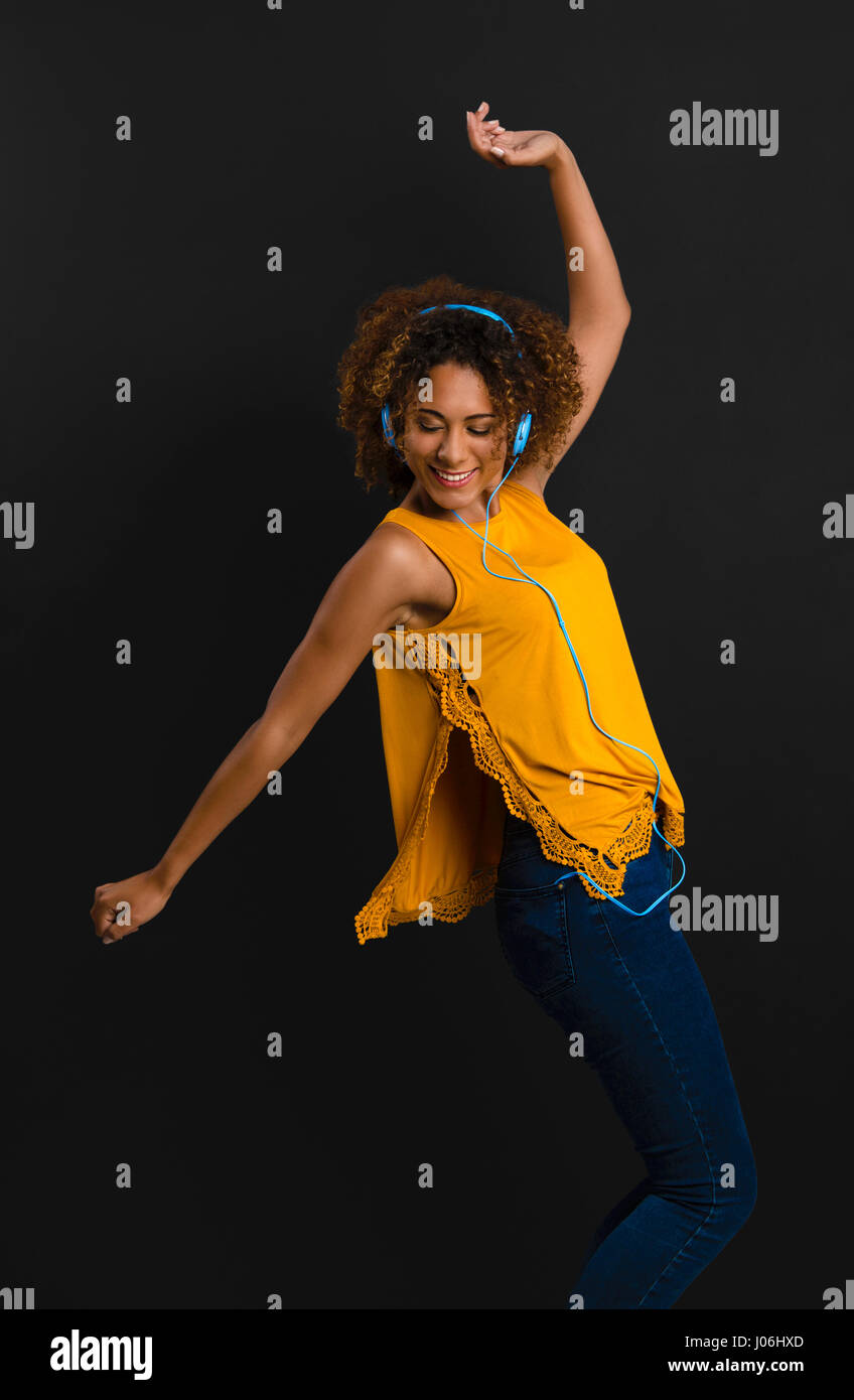 Bella americano africano donna ascoltare musica e ballo Foto Stock