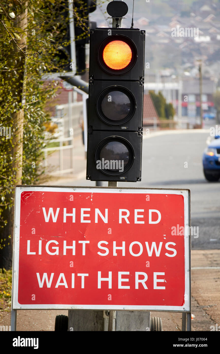 Quando la spia rossa mostra attendere segno qui sotto Semafori provvisori presso le riparazioni stradali Newtownabbey Regno Unito Foto Stock