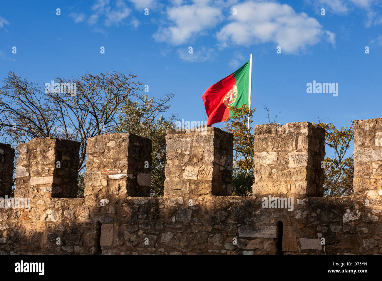 La bandiera portoghese vola sopra i bastioni del Castelo do São Jorge, Lisbona, Portogallo Foto Stock
